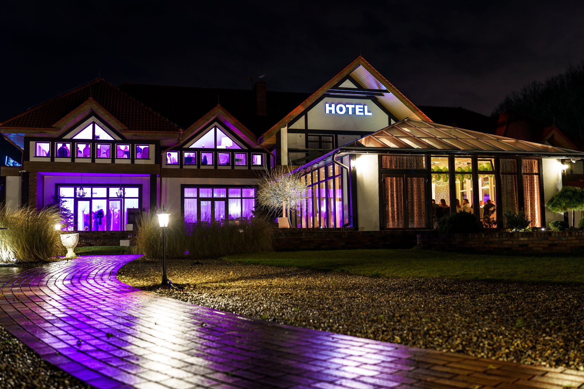 Dworek Bukowy Park nocą w fioletowej iluminacji - bale i studniówki