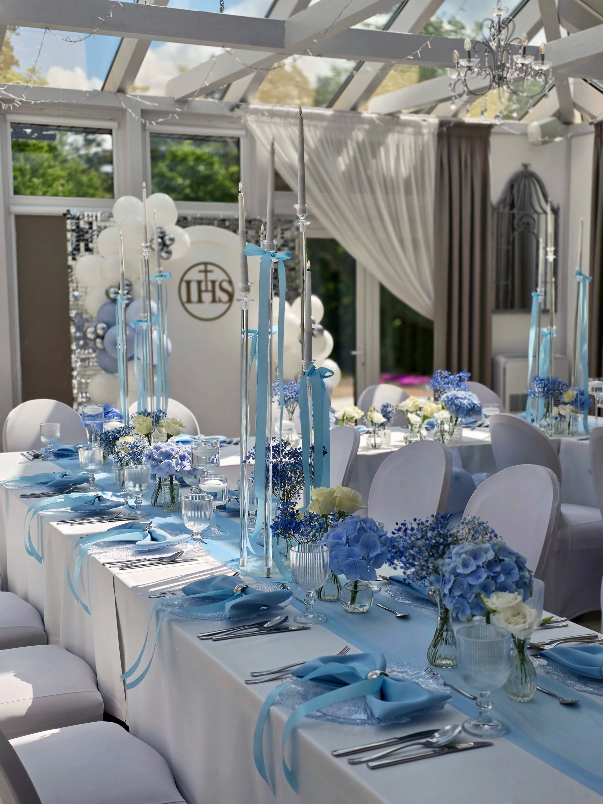 Stół komunijny w Oranżerii z błękitną dekoracją, świecami i hortensjami, Dworek Bukowy Park